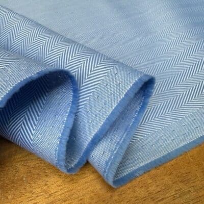 Blue herringbone pocketing fabric folded on a table