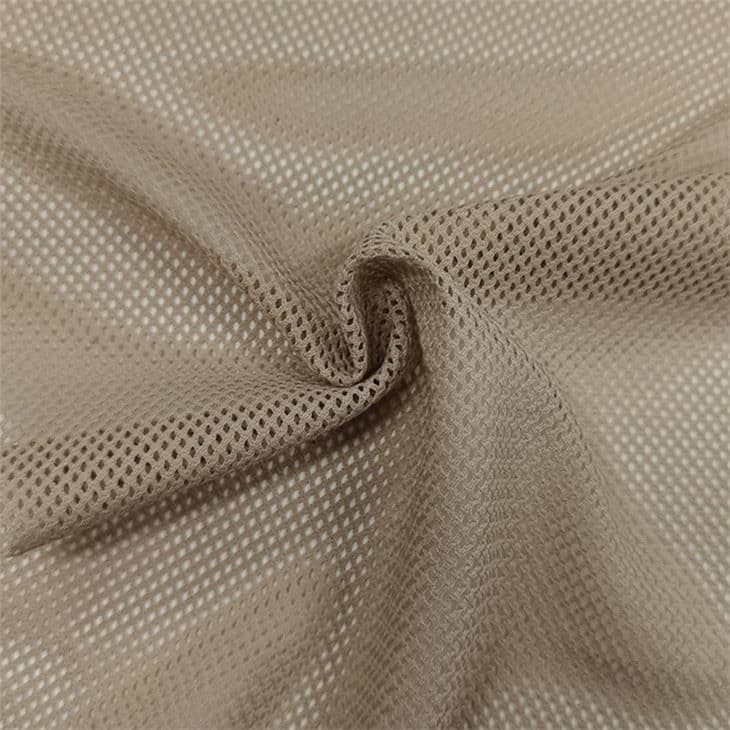 Beige polyester mesh fabric in a swirl