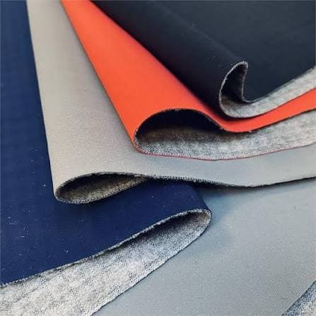 Solid colour fabrics layered in navy, grey, orange and black